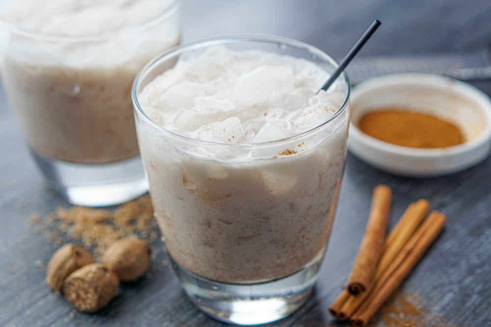 closeup of 2 glass of keto rumchata drinks with fresh nutmeg and cinnamon sticks