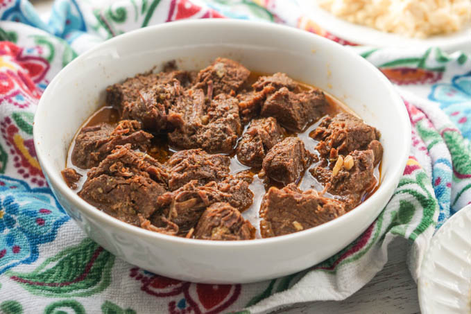 A white bowl with chunks of the Middle Eastern spiced pot roast.