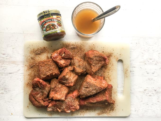 Photo of the spice rubbed meat chunks with a cup of broth.