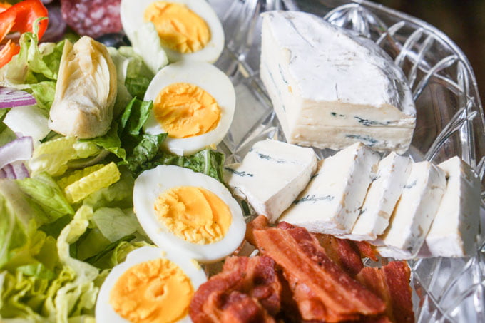 Close up of salad platter showing Borgonzola cheese, bacon and eggs.