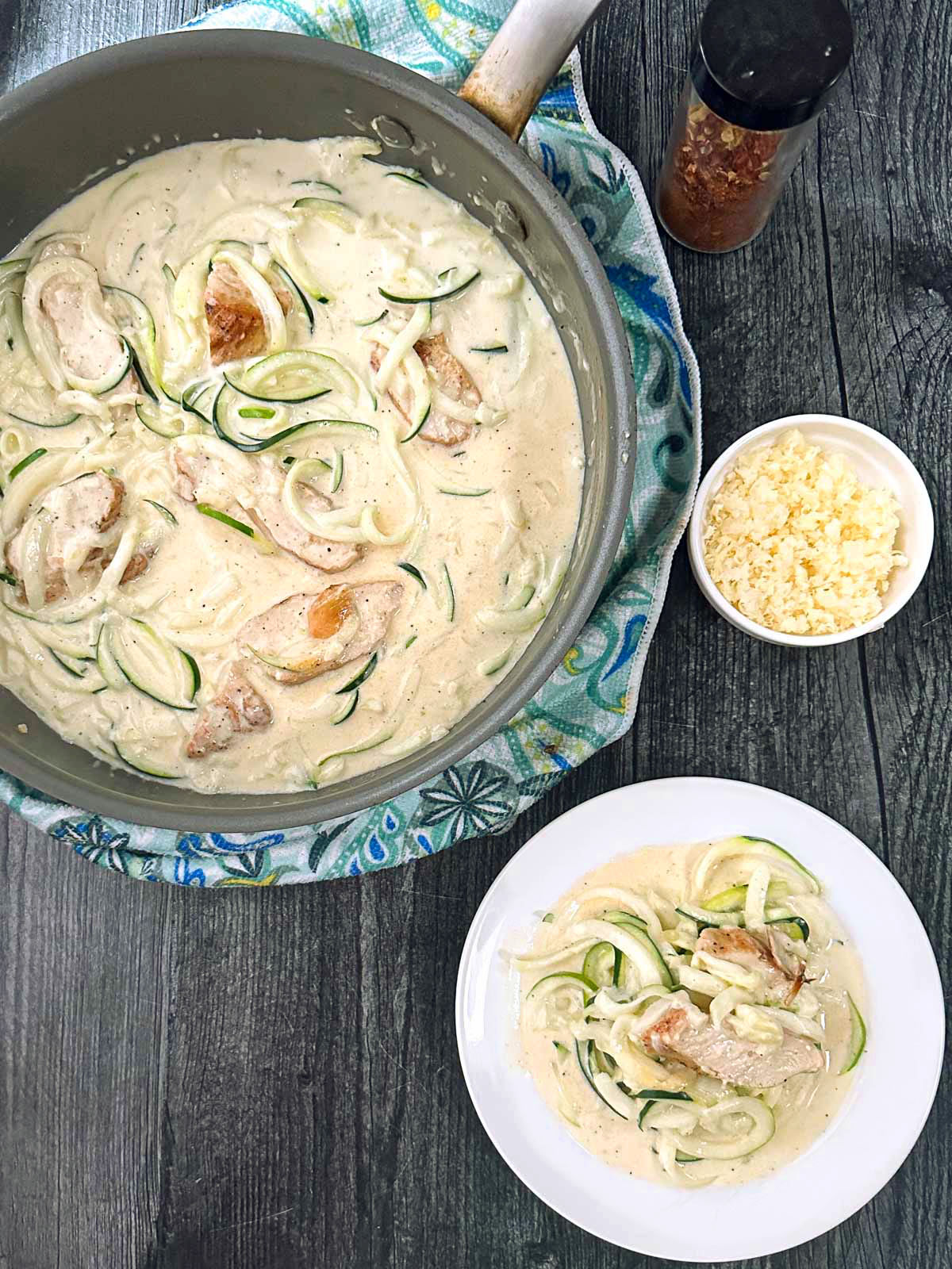 aerial view of a pan and plate with low carb zoodles in creamy sauce with chicken