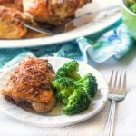 white plate with rotisserie chicken thigh and broccoli