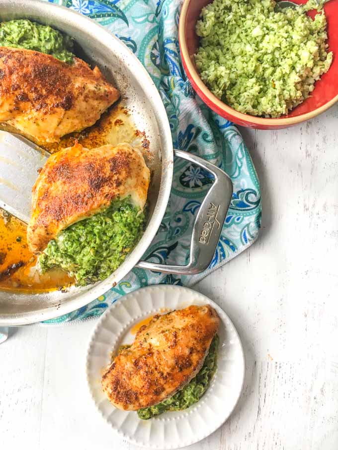 long photo of pan of stuffed chicken breast with a white plate and bowl of cauliflower rice