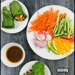 Aerial view of collard greens keto spring rolls with the dipping sauce and all the chopped veggies and text overlay.
