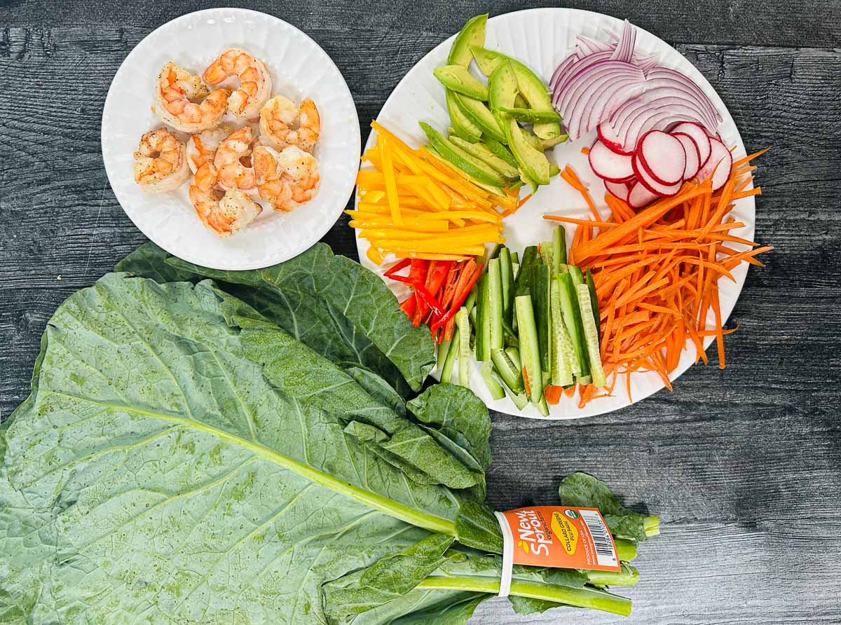 Recipe ingredients - collard greens, cooked shrimp, chopped vegetables, sliced avocados. 