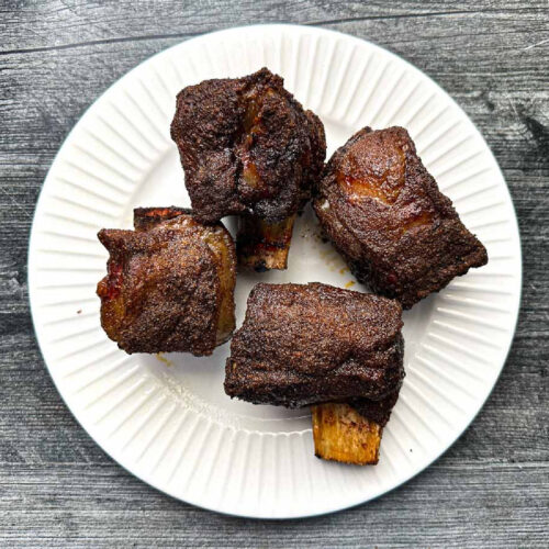 White plate with 4 bbq smoked short ribs.