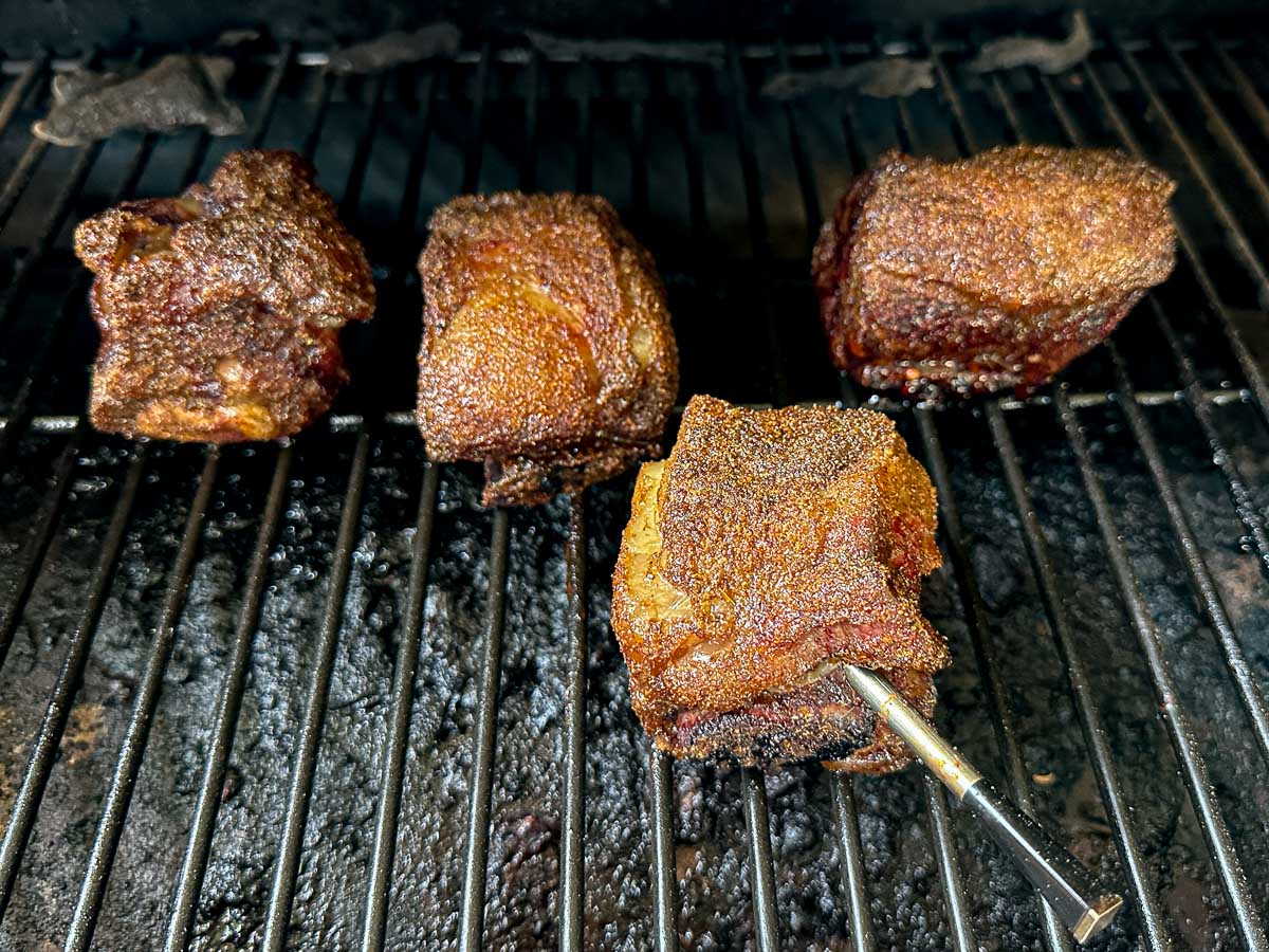 The ribs on the grill of the smoker.
