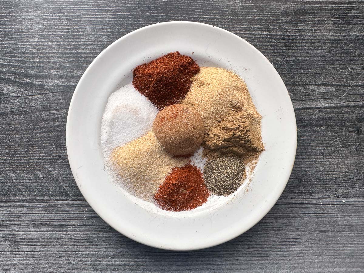 White plate with all the spice rub spices.