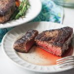 white plate with juicy red steak that's been sous vide