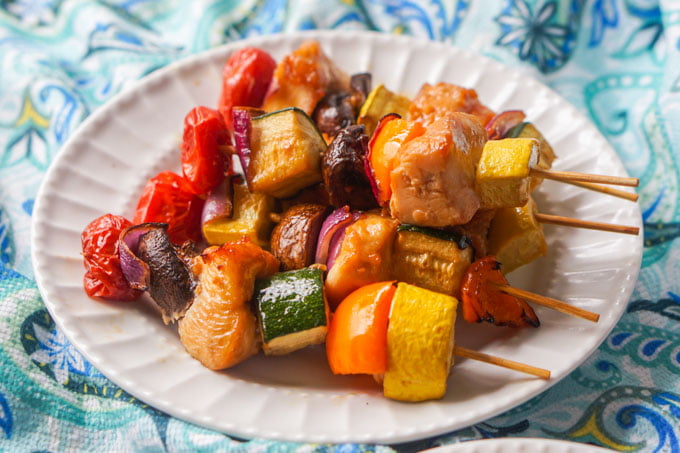 white plate with Asian chicken and vegetable kebabs