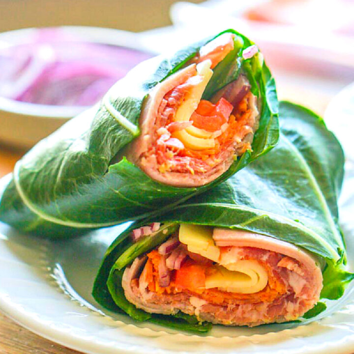 A white plate with a keto collard wrap with sub sandwich filings.
