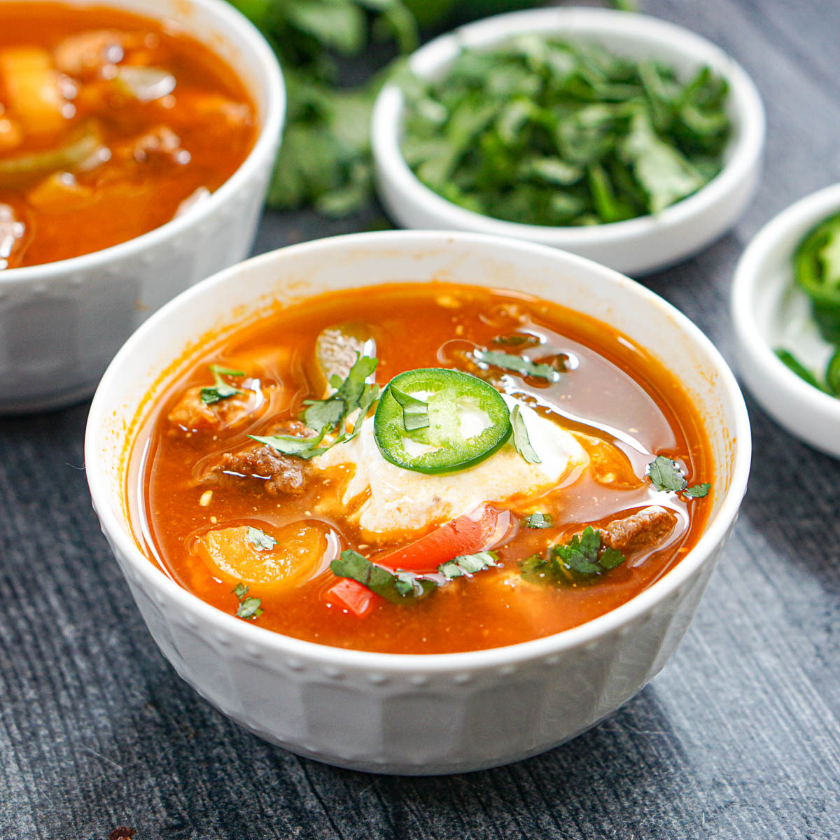 White bowl with low carb fajita soup made in the instant pot with cilantro in the background.