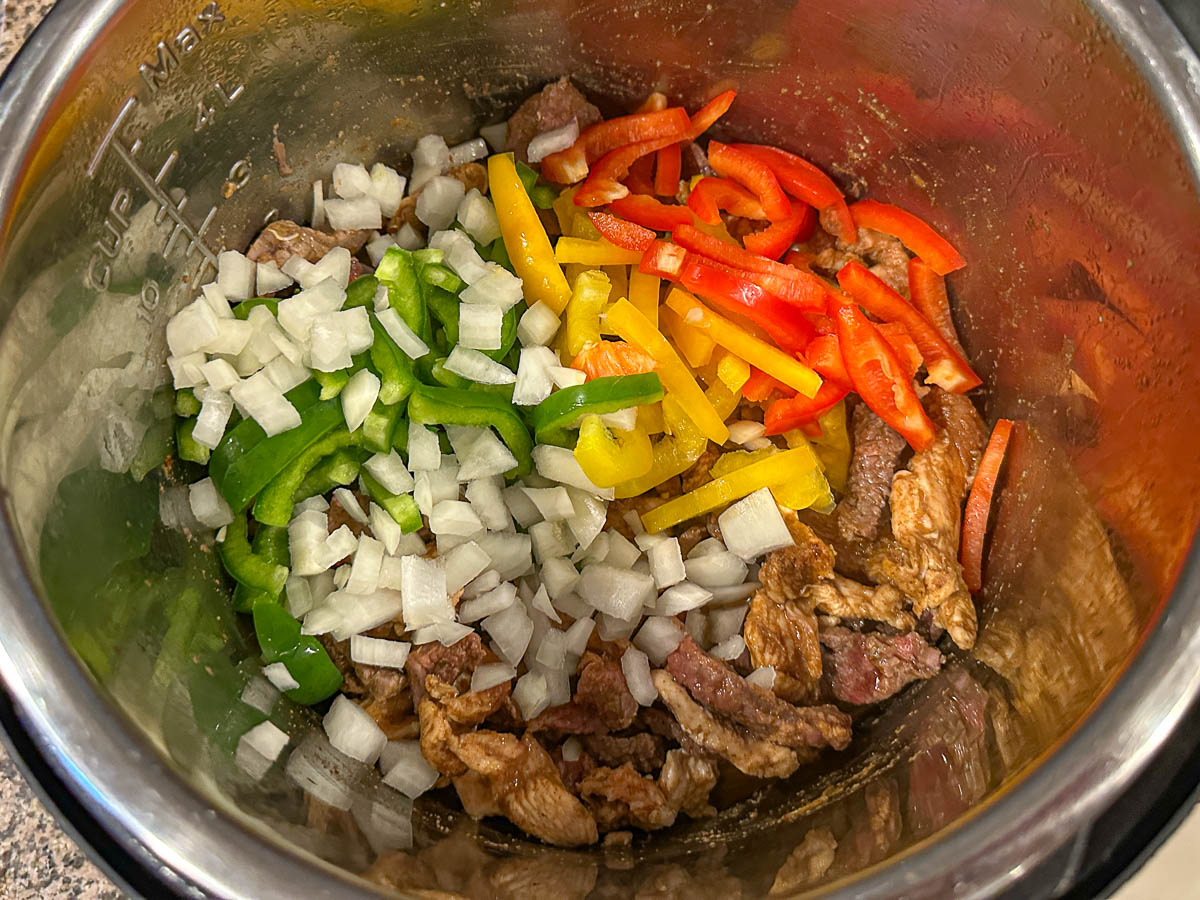 Instant pot with the vegetables added to the meat.
