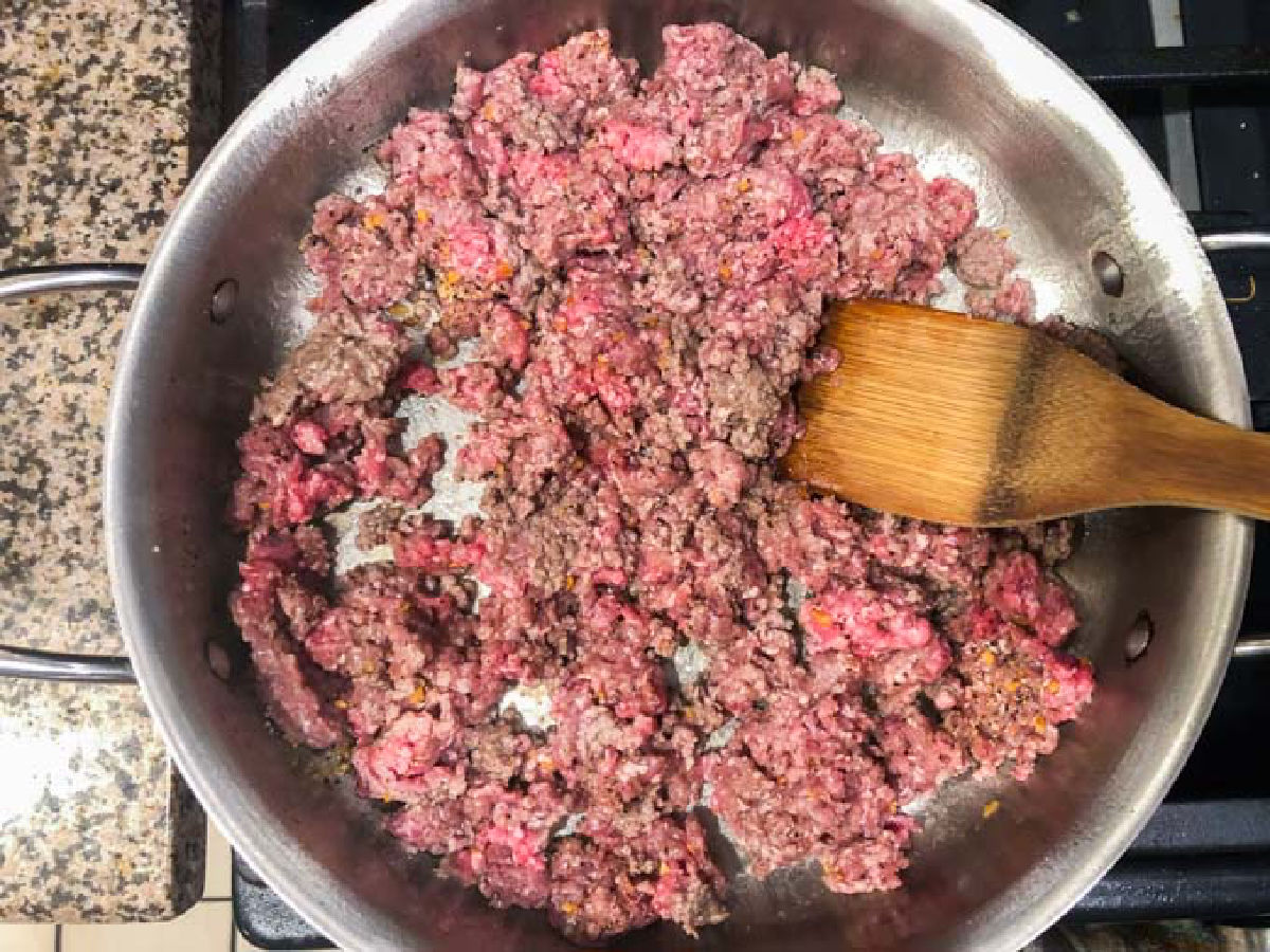 A plan with raw ground beef and seasonings.