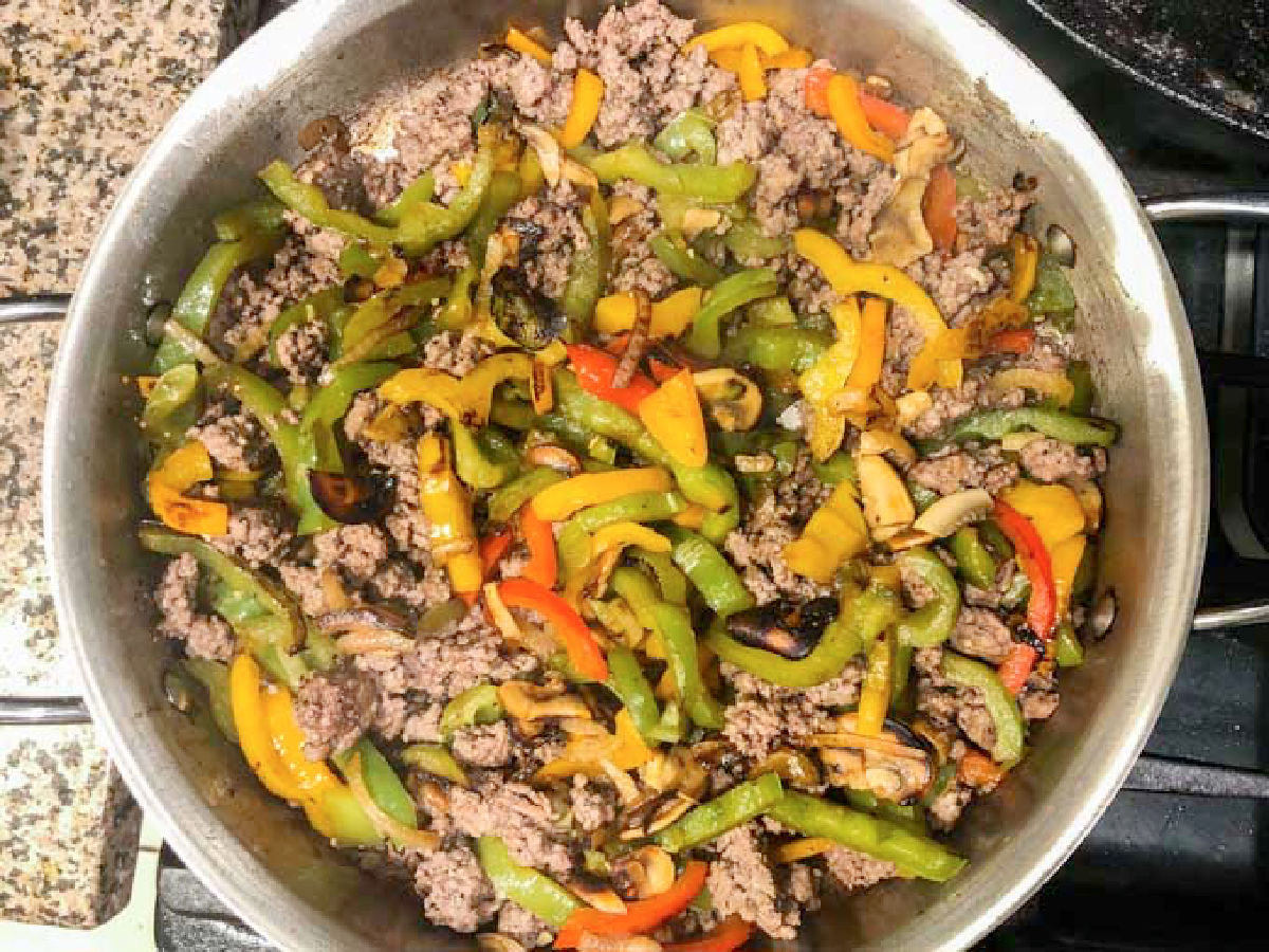 A skillet with both the ground meat and veggies.
