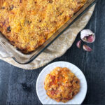 baking dish and whit plate with low carb chicken casserole and fresh garlic cloves with text