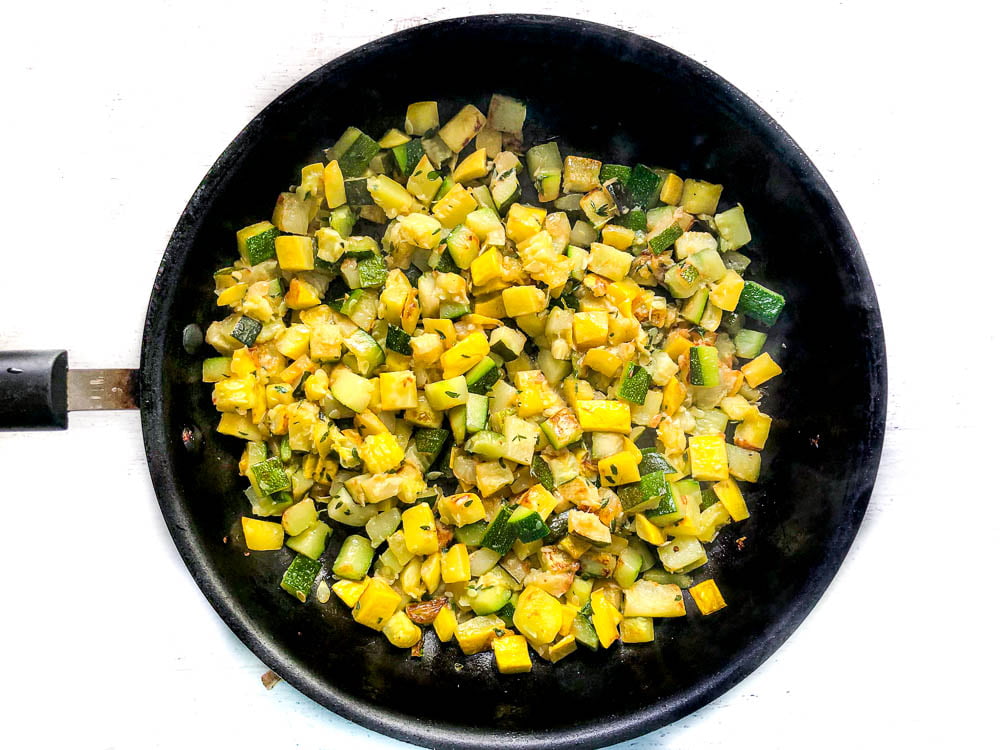 black skillet with sauted yellow and green zucchini