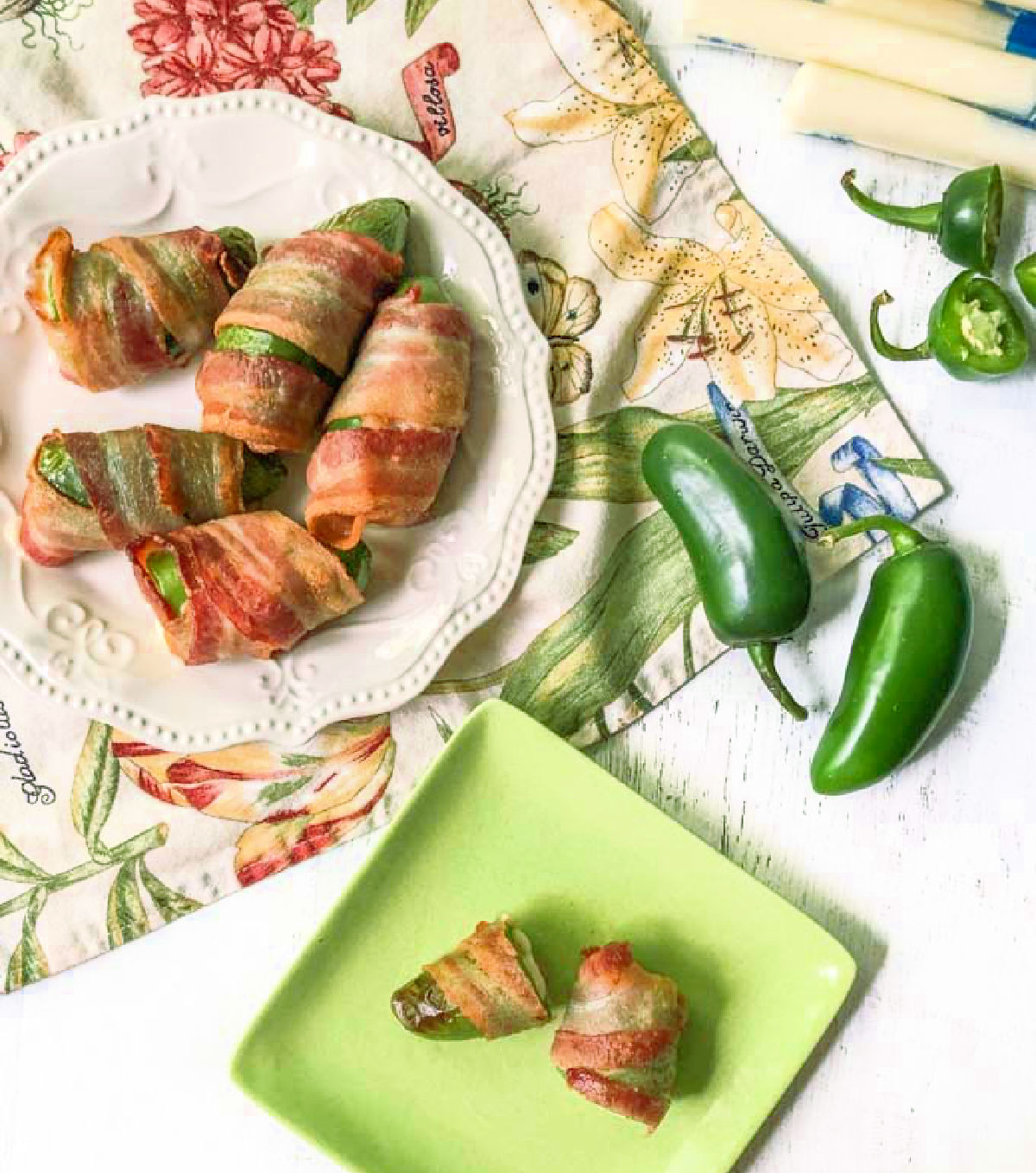 Aerial view of green plate with 2 air fryer bacon wrapped jalapenos.