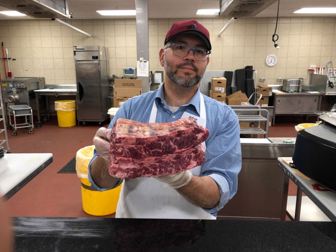 butcher holding pieces of beef 