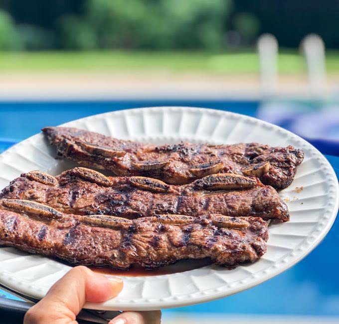platter with grilled flanken short ribs and pool in background