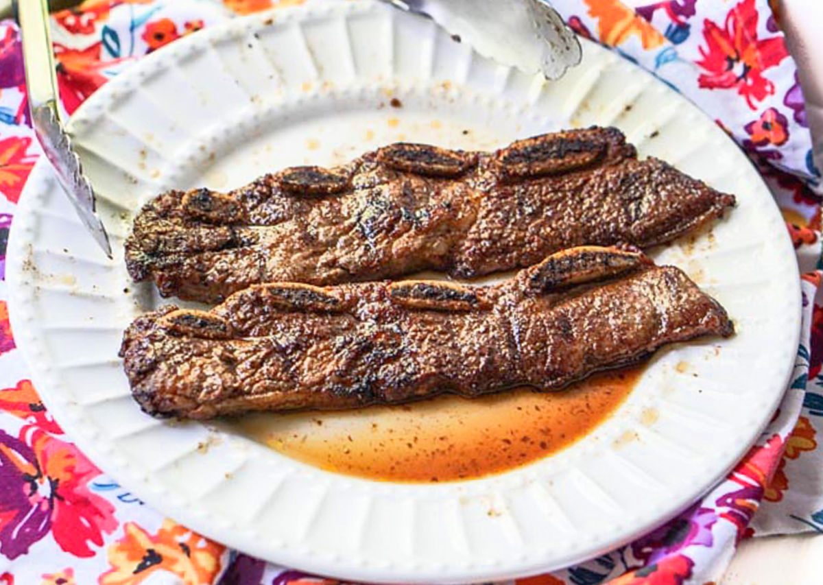 White plate on a colorful tea towel with finished recipe.