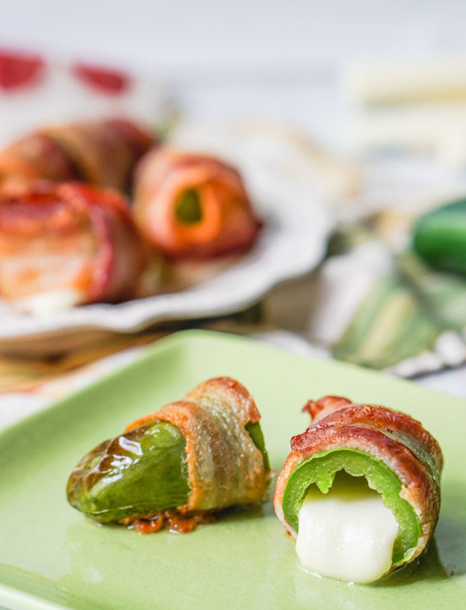 closeup of bacon wrapped jalapeño cut in half with cheese oozing out