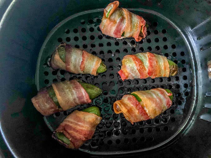 cooked bacon wrapped jalapeños in air fryer basket