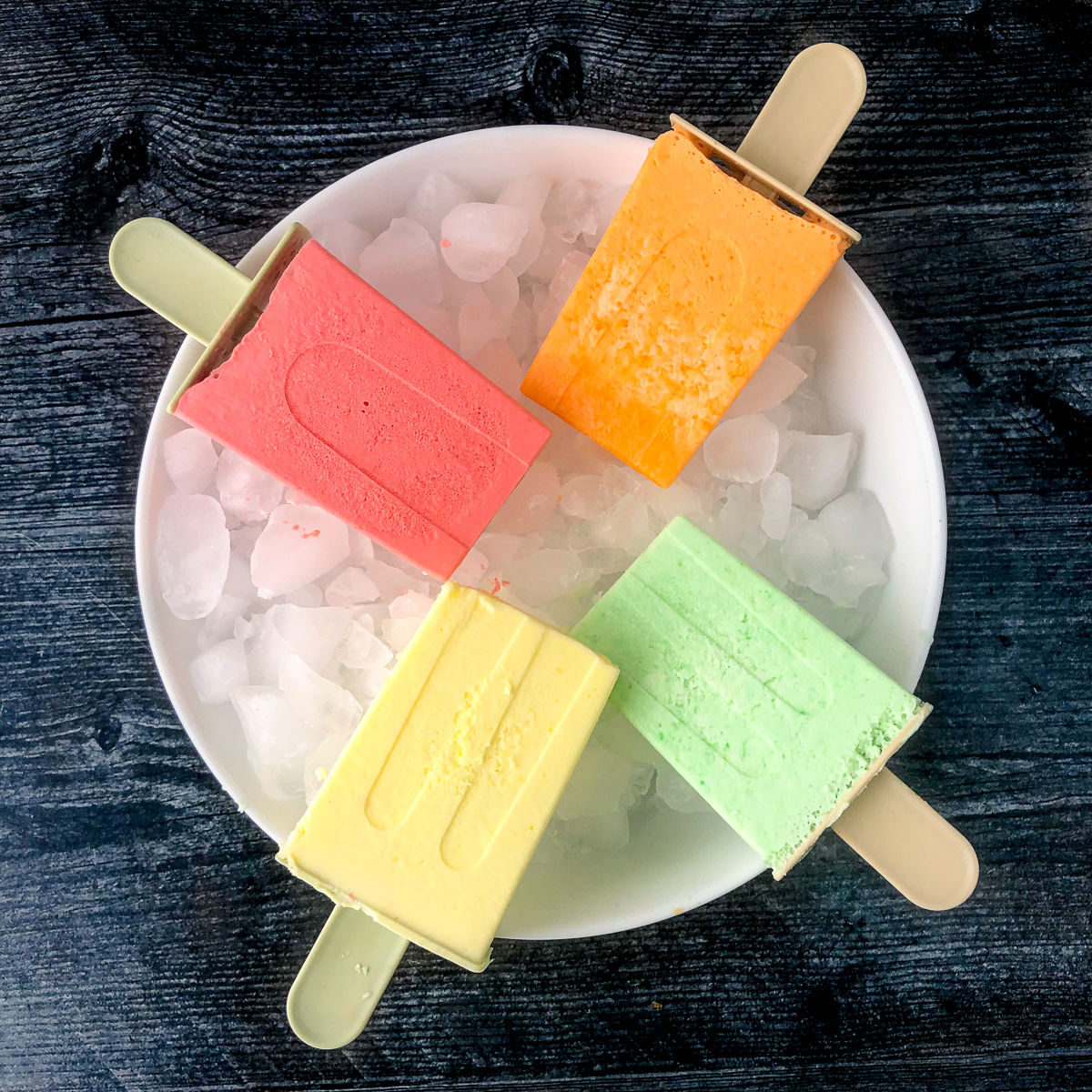 white bowl with ice and 4 different flavored sugar free jello popsicles