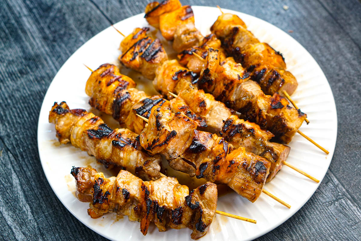 Closeup of a white plate with the finished skewers.
