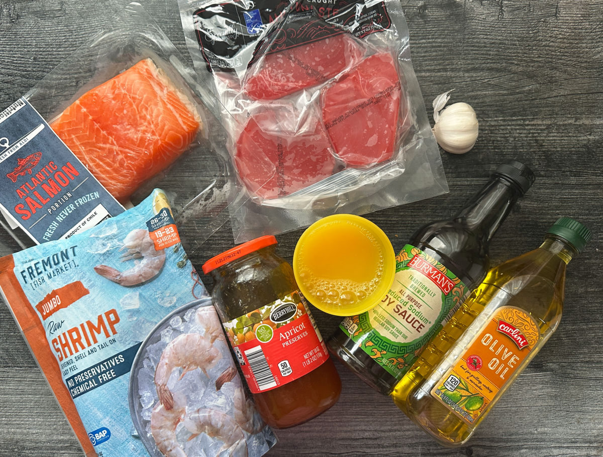 Recipe ingredients - salmon, tuna, shrimp, orange juice, apricot jam, olive oil, garlic and soy sauce.
