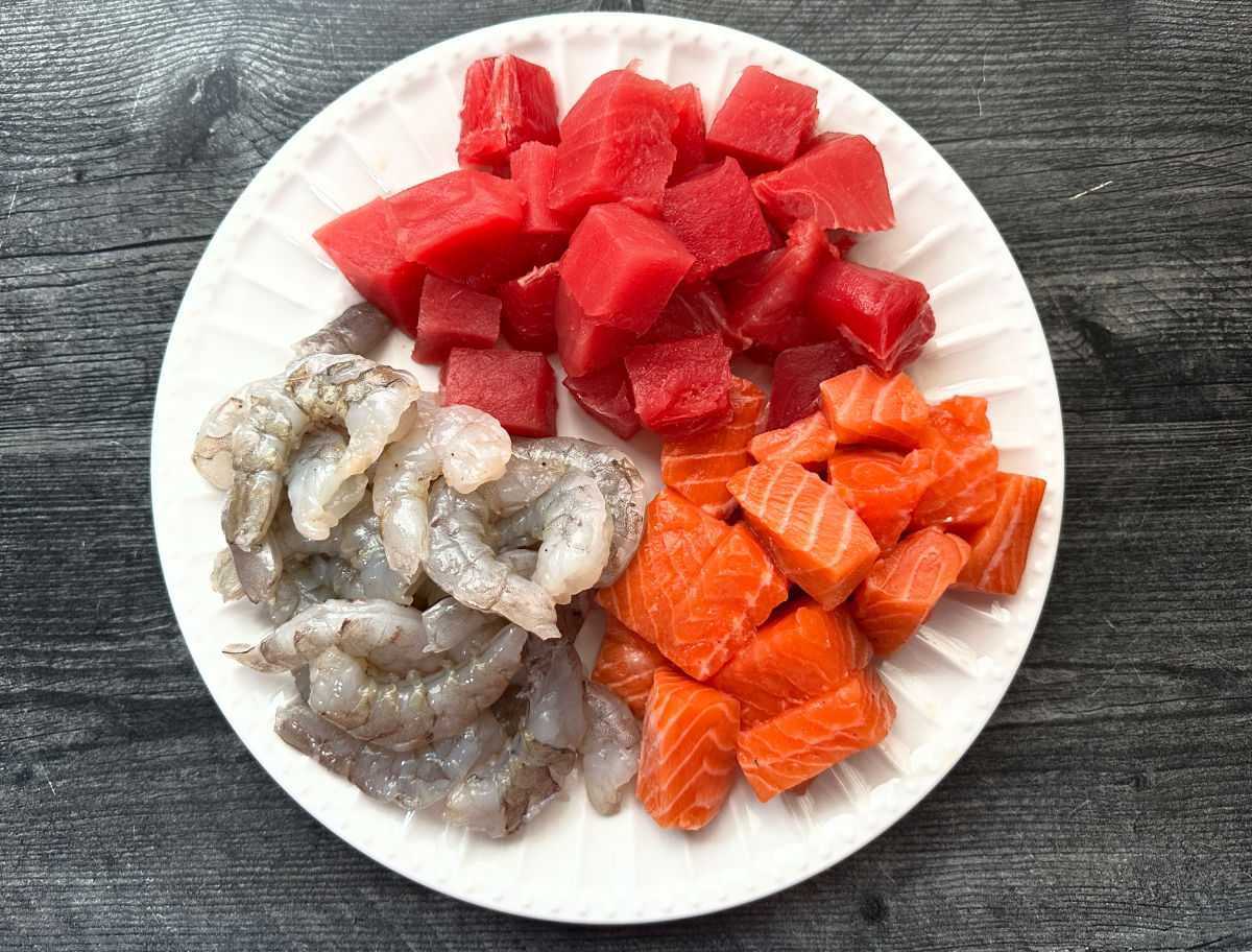 Apricot Orange Grilled Seafood Kebabs - easy, healthy and tasty dinner on the grill! Plate with raw shrimp and tuna and salmon pieces.