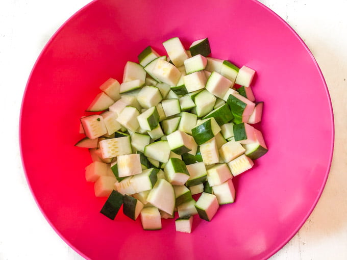 chopped zucchini in pink bowl