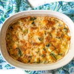 baking dish with low carb zucchini au gratin on blue tea towel