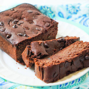 White plate with a loaf of keto chocolate zucchini bread with chocolate chips.
