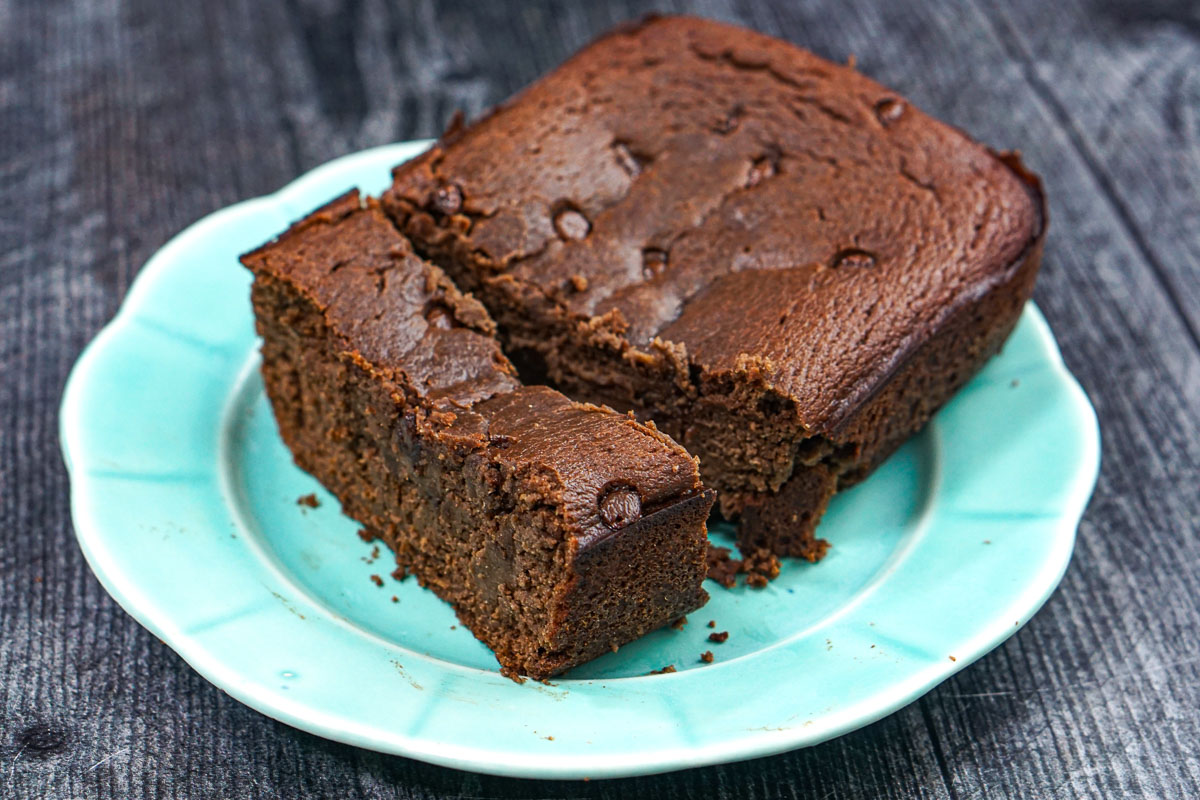 Aqua plate with the loaf of finished chocolate bread with a slice.