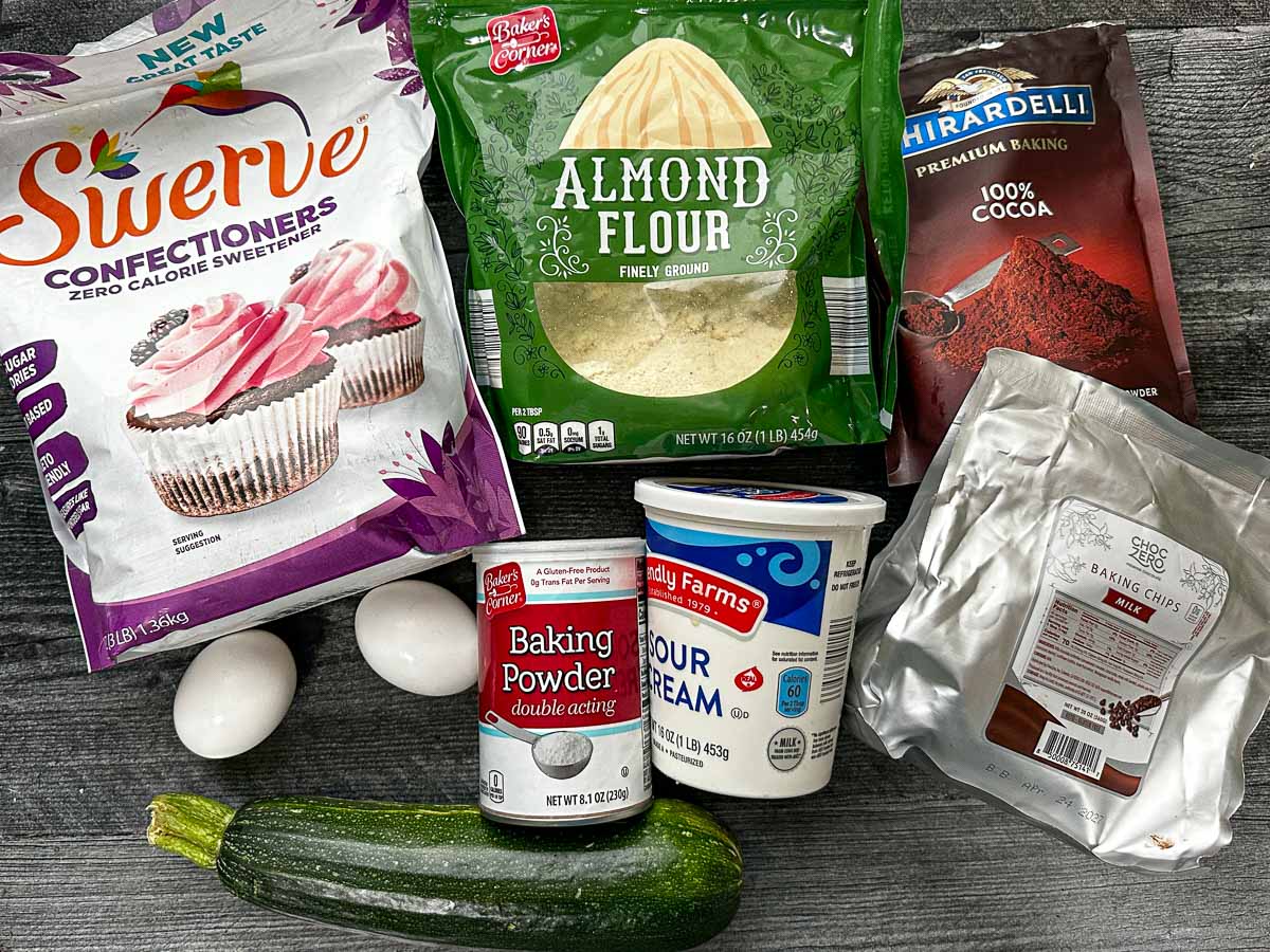 Recipe ingredients - Swerve sweetener, almond flour, cocoa powder, eggs, zucchini, baking powder, sour cream, keto chocolates.