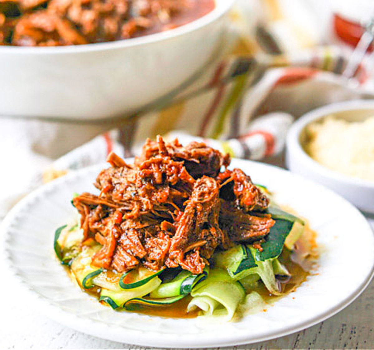 white plate with zucchini noodles and Instant Pot shredded beef