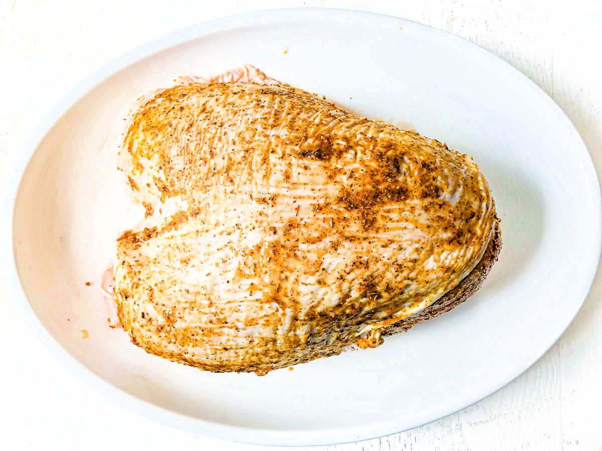 White platter with the prepared raw roast.