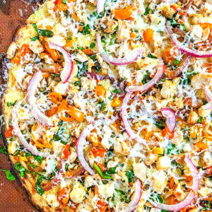 closeup of keto chicken and veggie cauliflower crust pizza