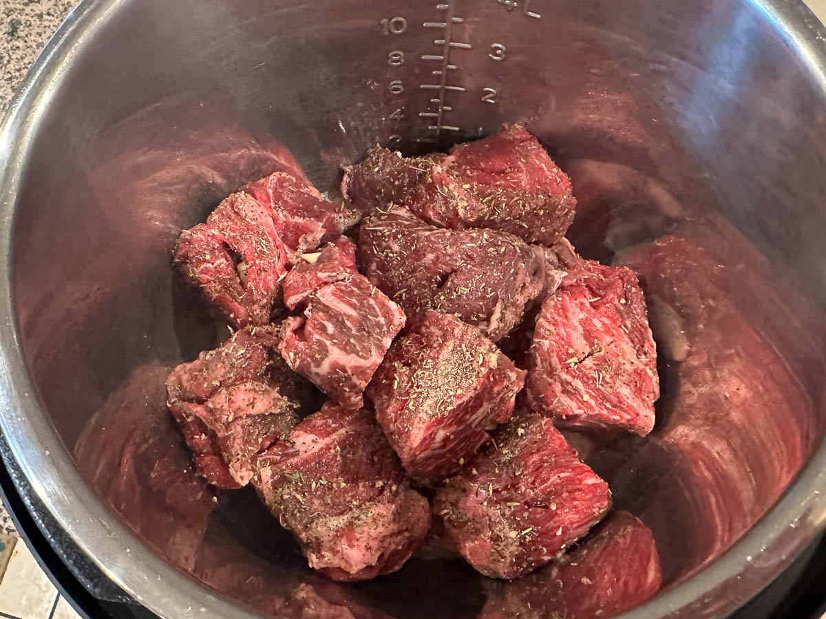 instant pot with raw chunks of beef