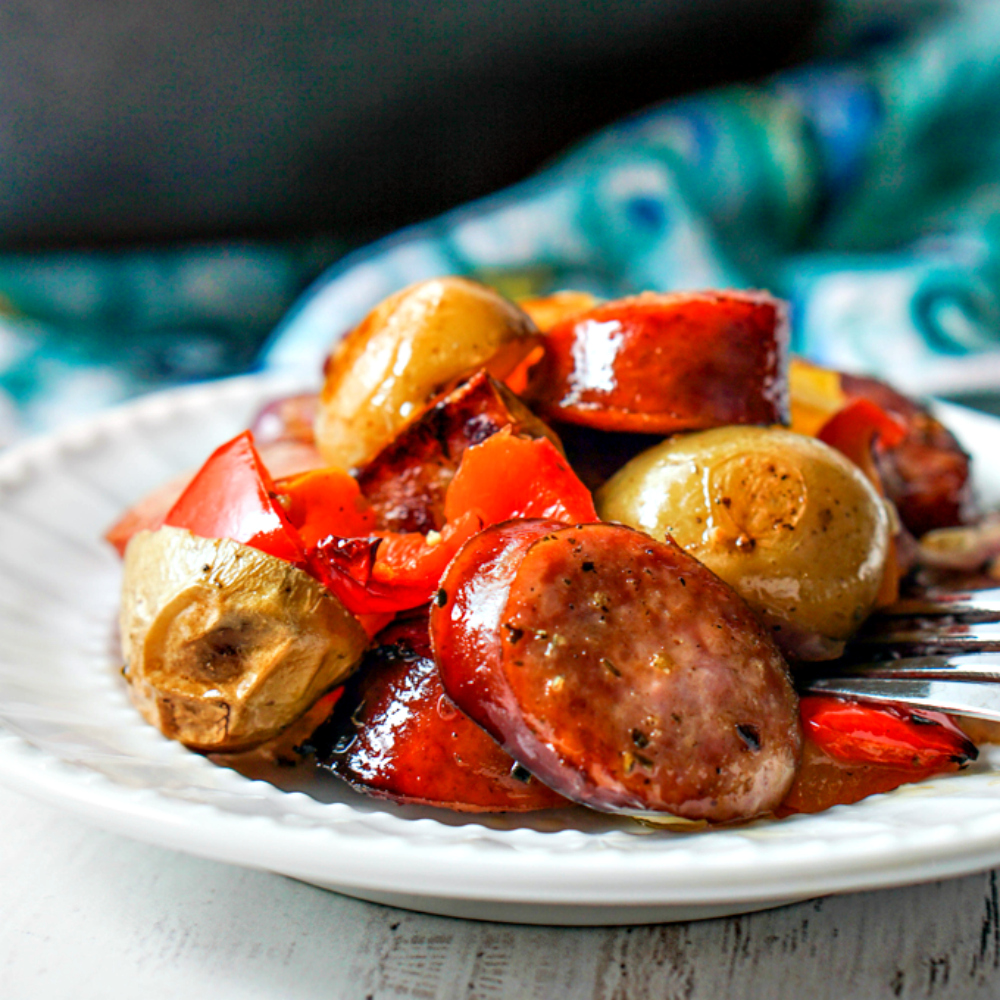 white plate with kielbasa and potatoes and peppers