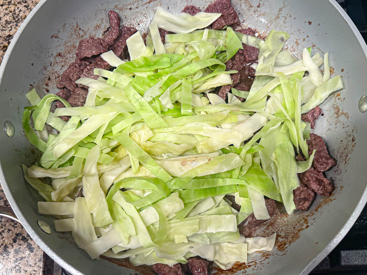 Skillet with the cabbage noodles added.