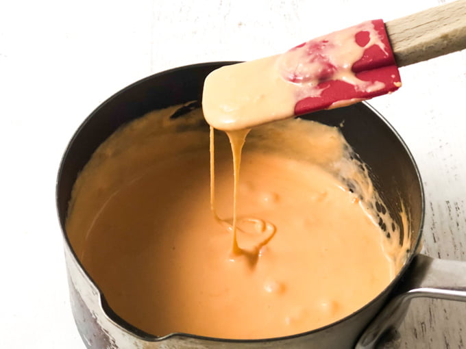 pan of melted cheese sauce and spatula 