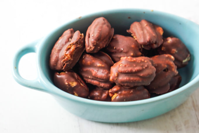 closeup of blue bowl with low carb chocolate covered pecans