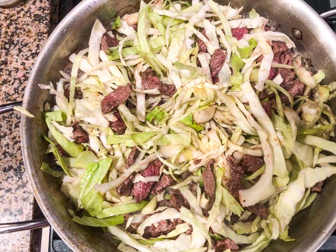 saute pan with beef and cabbage about to be cooked