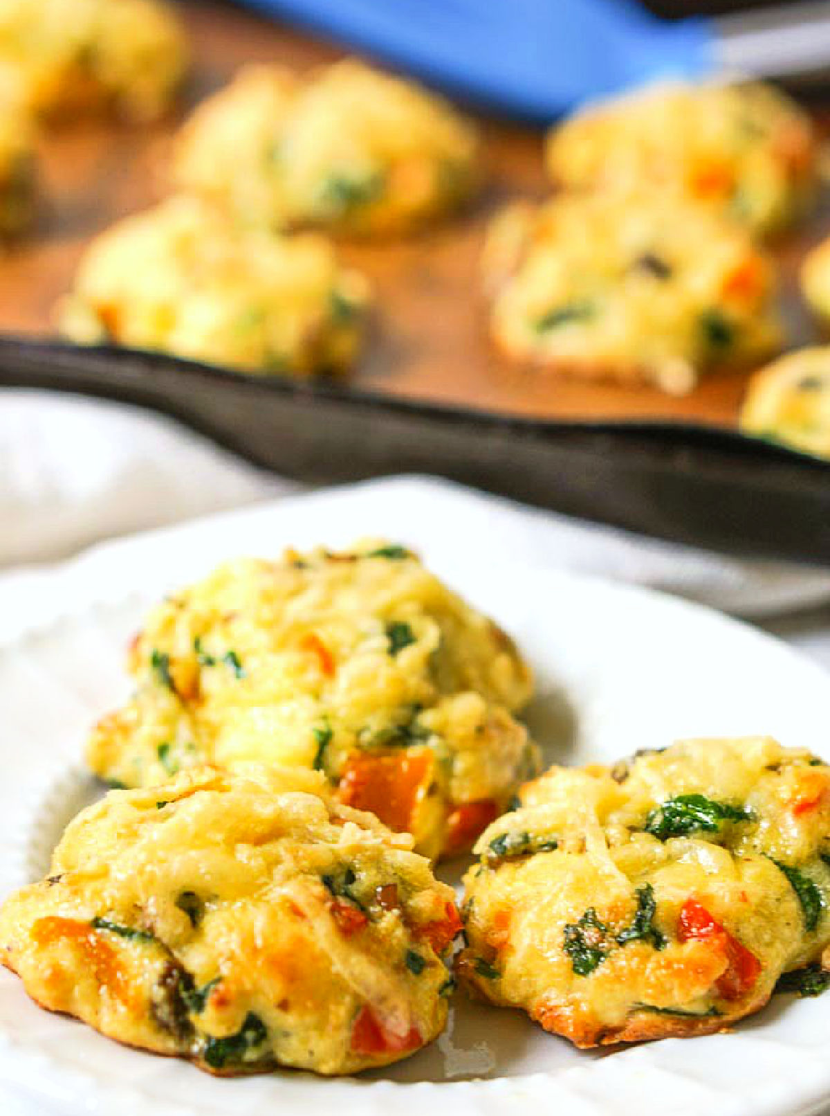 Closeup of a plate of the gluten free low carb veggie cookies with a tray in the background.