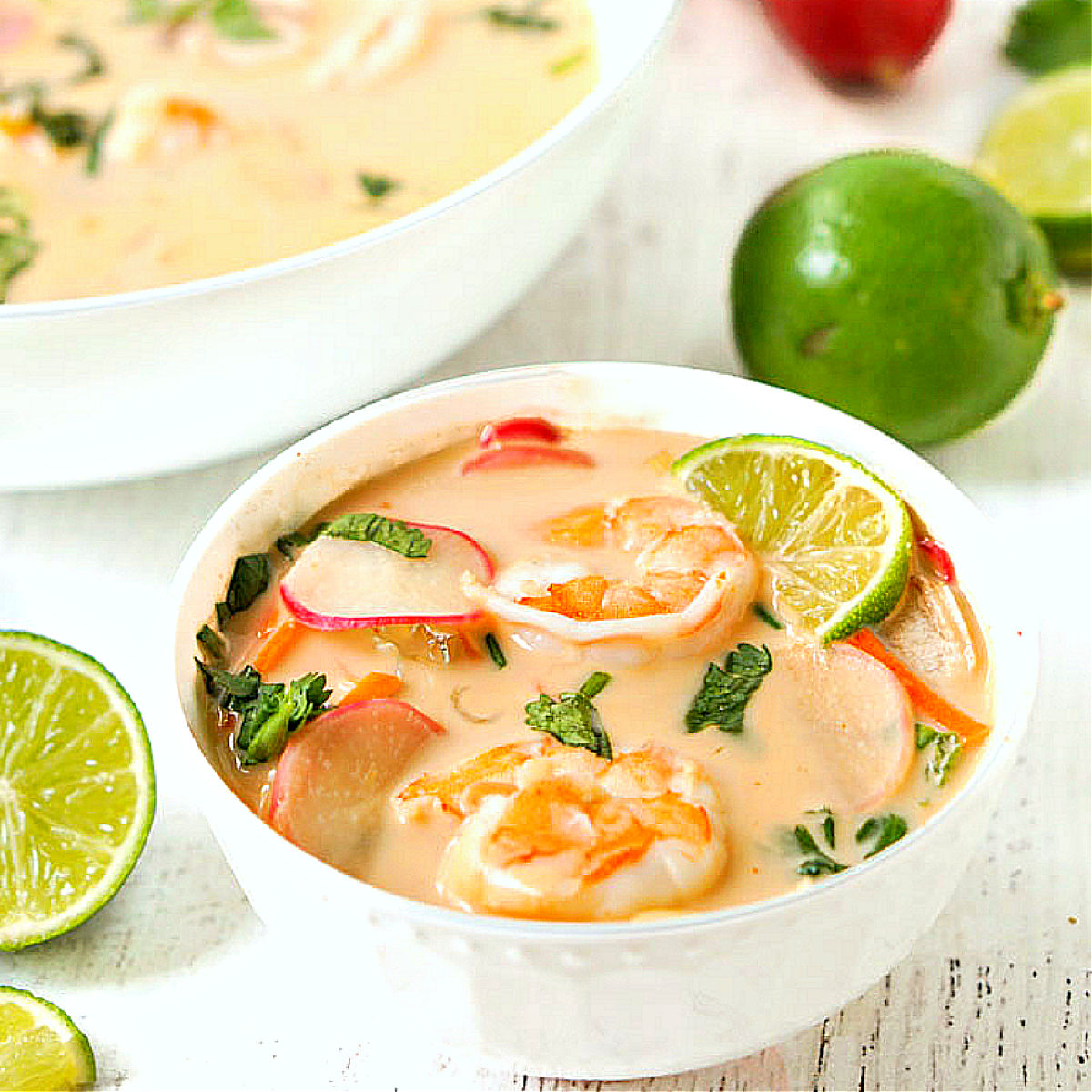 Closeup of a white bowl with keto shrimp Thai curry soup.