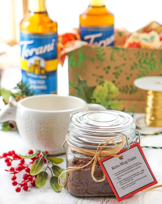 glass jar with keto mug cake mix, a lama mug and decorative gift box and cords in background