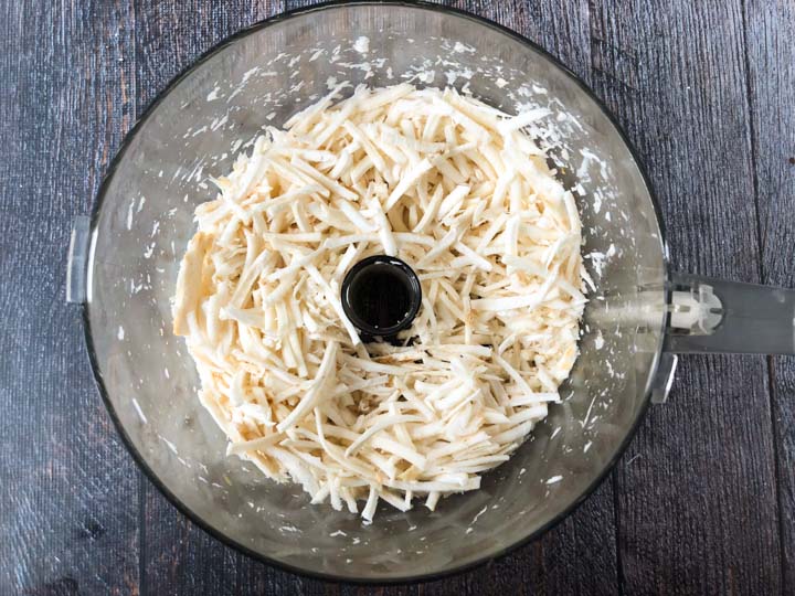 bowl of food processor with grated fresh horseradish