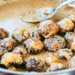 Closeup of a pan of keto creamy mushrooms with a serving spoon.